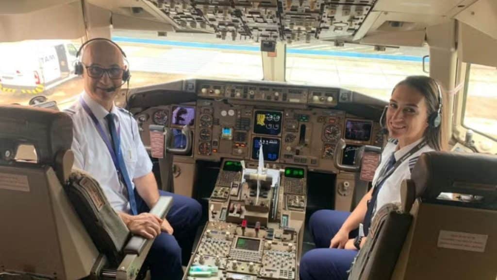 Imagem de pai e filha dentro de um avião para representar a matéria do Dia do Aviador.