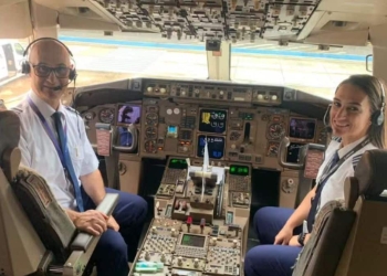 Imagem de pai e filha dentro de um avião para representar a matéria do Dia do Aviador.