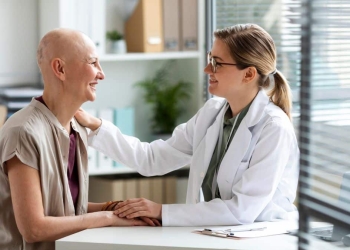 Médica ao lado de paciente com câncer.