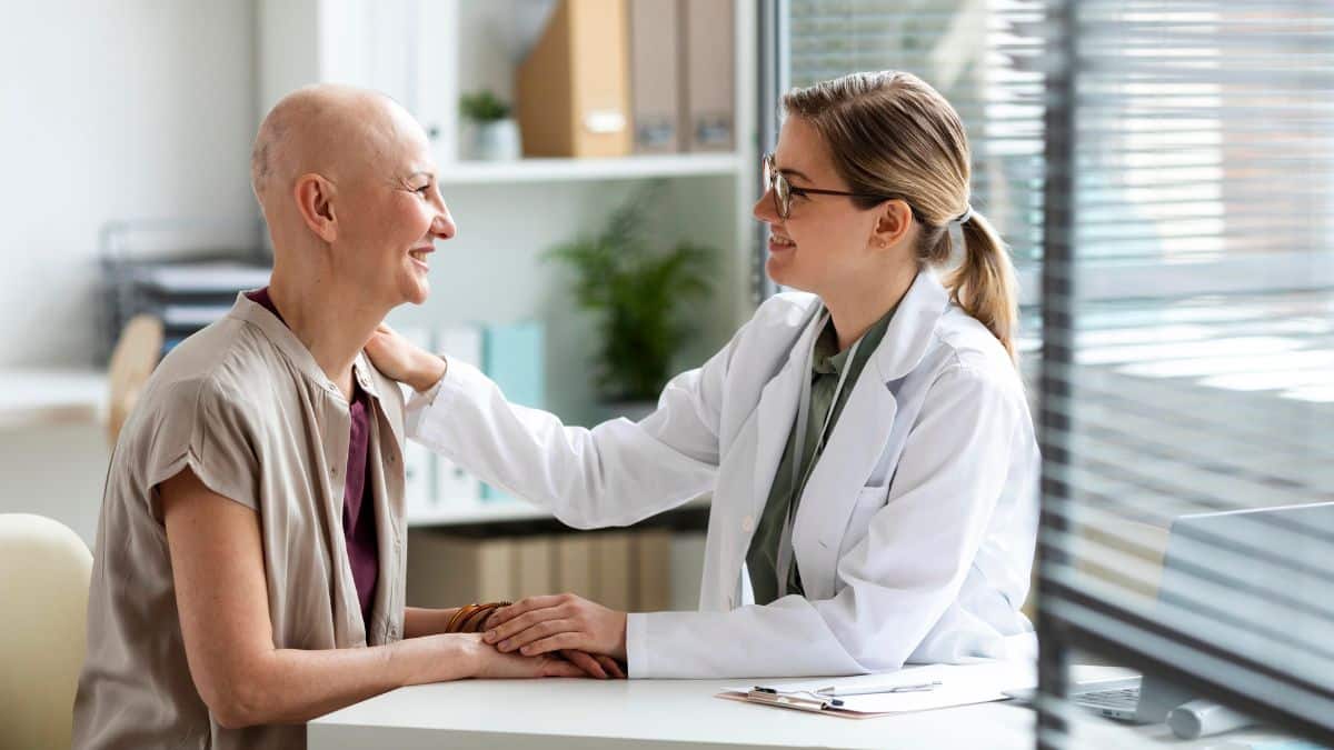 Médica ao lado de paciente com câncer.