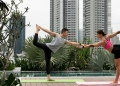 Imagem de casal praticando yoga para representar qualidade de vida em Singapura.