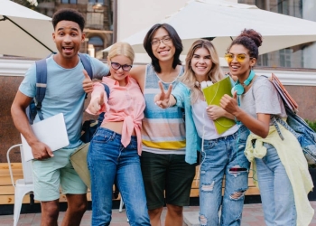 Estudantes felizes e sorrindo para a câmera.