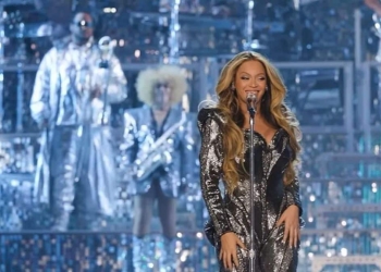 Beyoncé se apresentando no palco com trajes brilhantes.