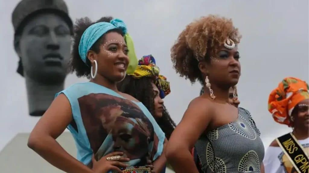 Mulheres negras com roupas e adereços tradicionais celebrando o Dia da Consciência Negra.