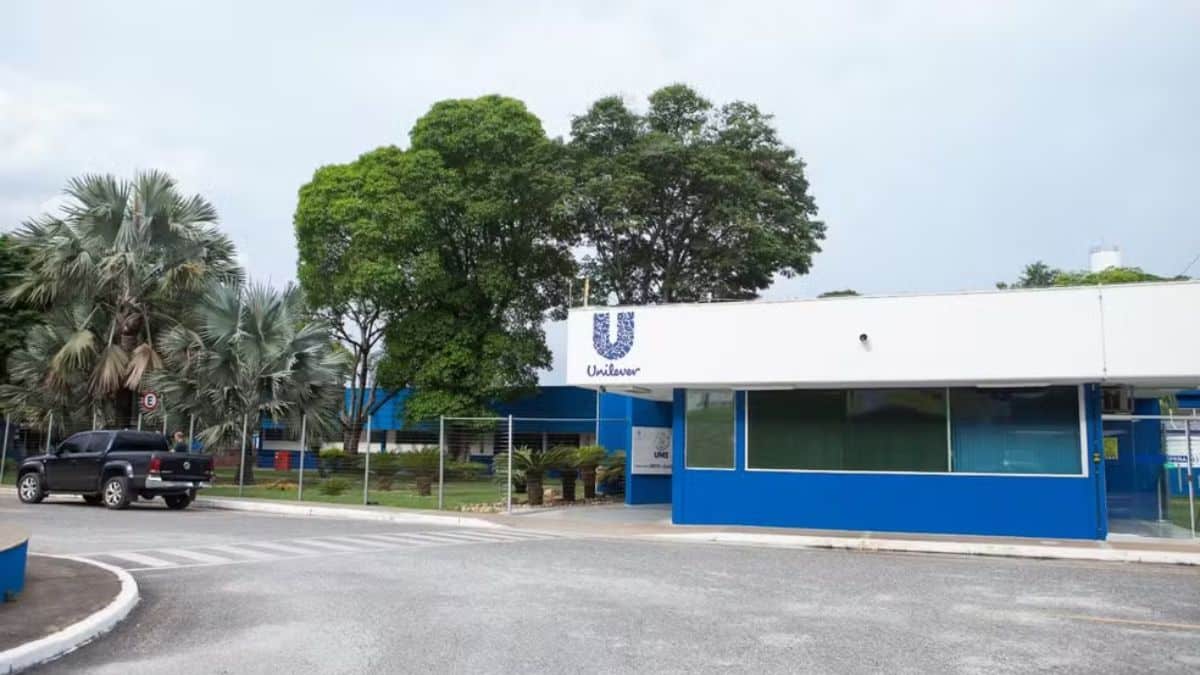 Entrada da unidade da Unilever com fachada azul e logotipo da empresa.