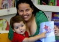 Mãe e filho com livro que conta a história de superação contra o câncer.