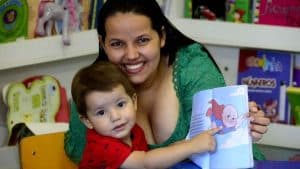 Mãe e filho com livro que conta a história de superação contra o câncer.