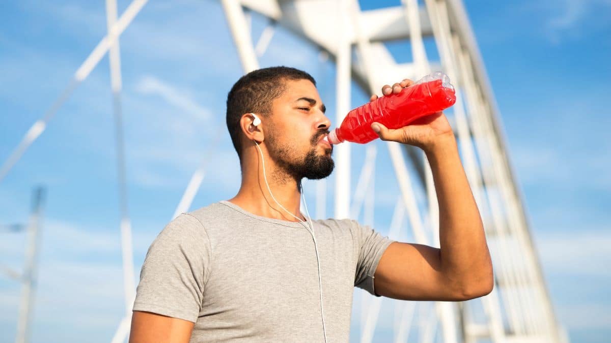 Homem bebendo isotônico após exercício ao ar livre.