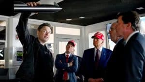 Elon Musk segurando um modelo da Starship, acompanhado por líderes políticos, incluindo Donald Trump, em uma reunião na base da SpaceX.