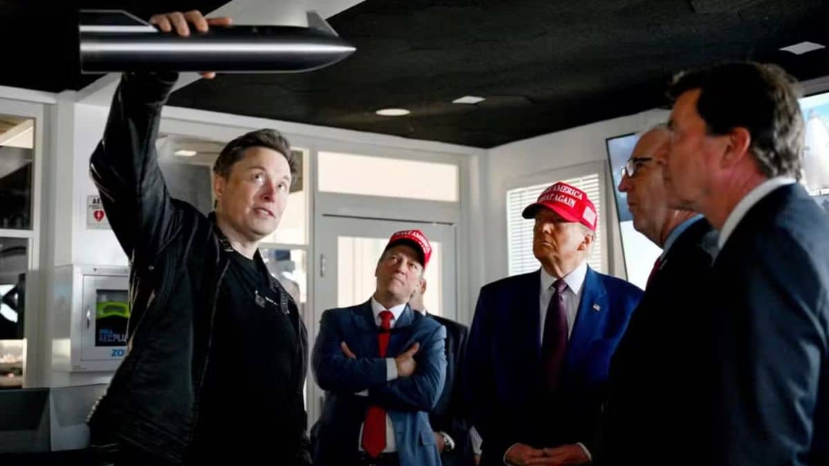 Elon Musk segurando um modelo da Starship, acompanhado por líderes políticos, incluindo Donald Trump, em uma reunião na base da SpaceX.