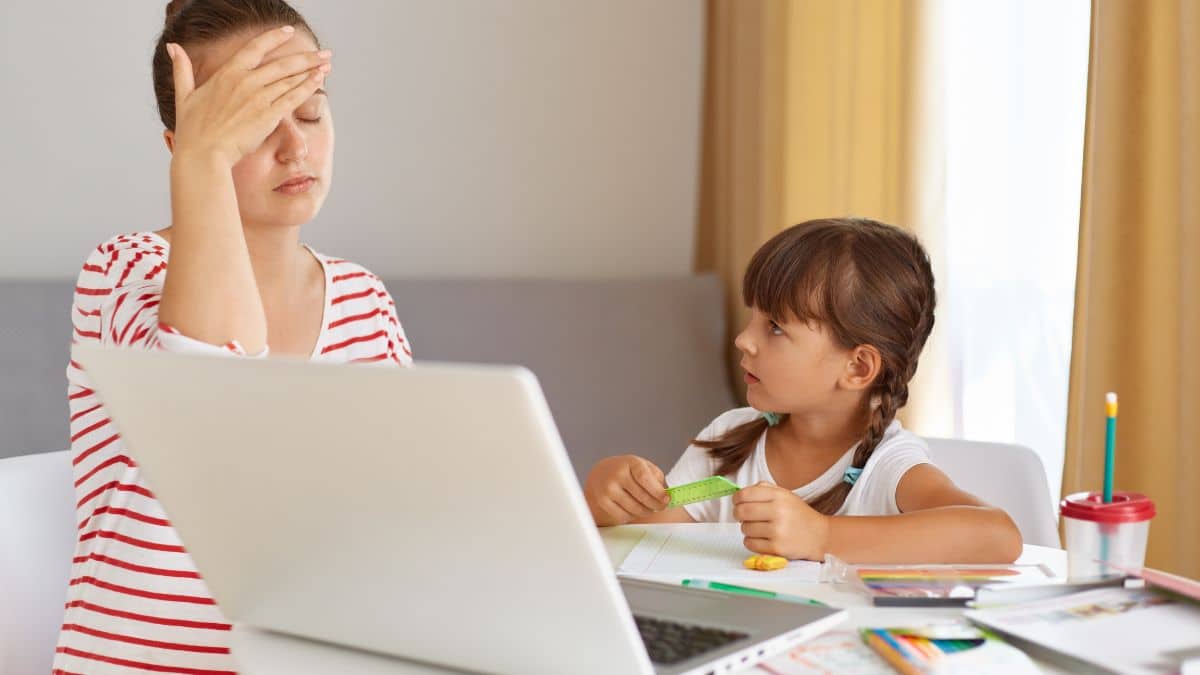 Mãe exausta tentando ensinar a tarefa para a filha, representando o aumento de diagnósticos de TDAH.