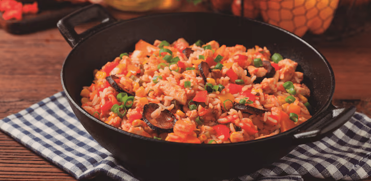 Prato típico de Nova Orleans, destaque entre as melhores cidades para comer em 2025, servido em panela de ferro com arroz, legumes e carnes.