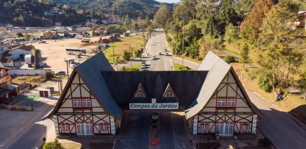 Portal de entrada de Campos do Jordão em dia ensolarado, principal acesso à cidade conhecida pelo turismo em todas as estações.