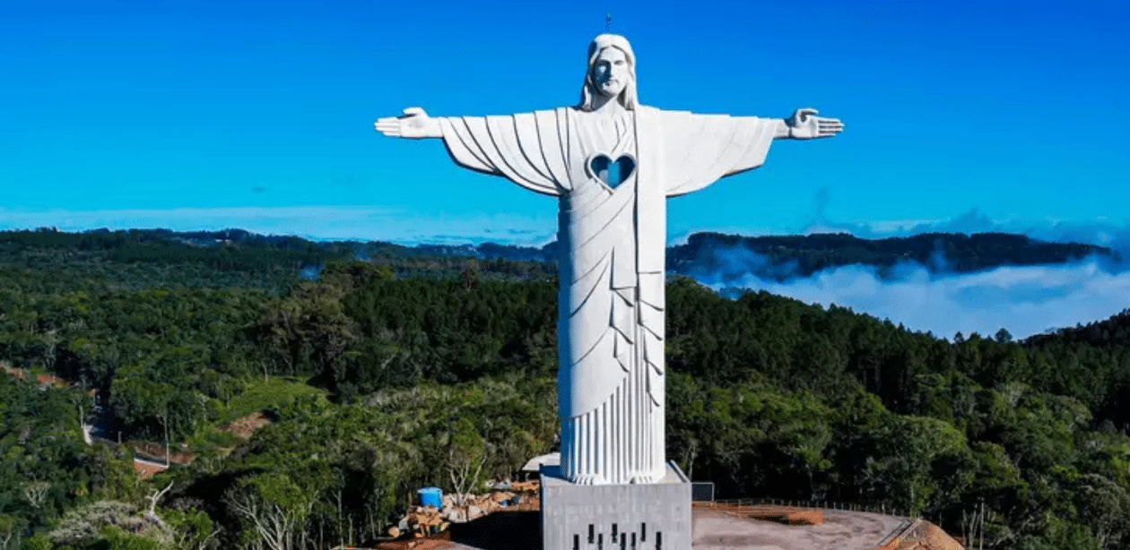 Vista frontal do Cristo Protetor de Encantado com os braços abertos sobre a paisagem do Rio Grande do Sul