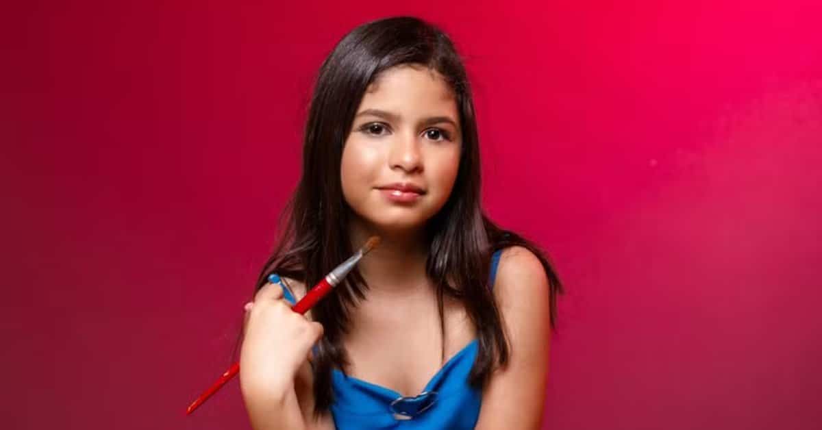 Artista de 11 anos posa com pincel antes de nova exposição em Paris