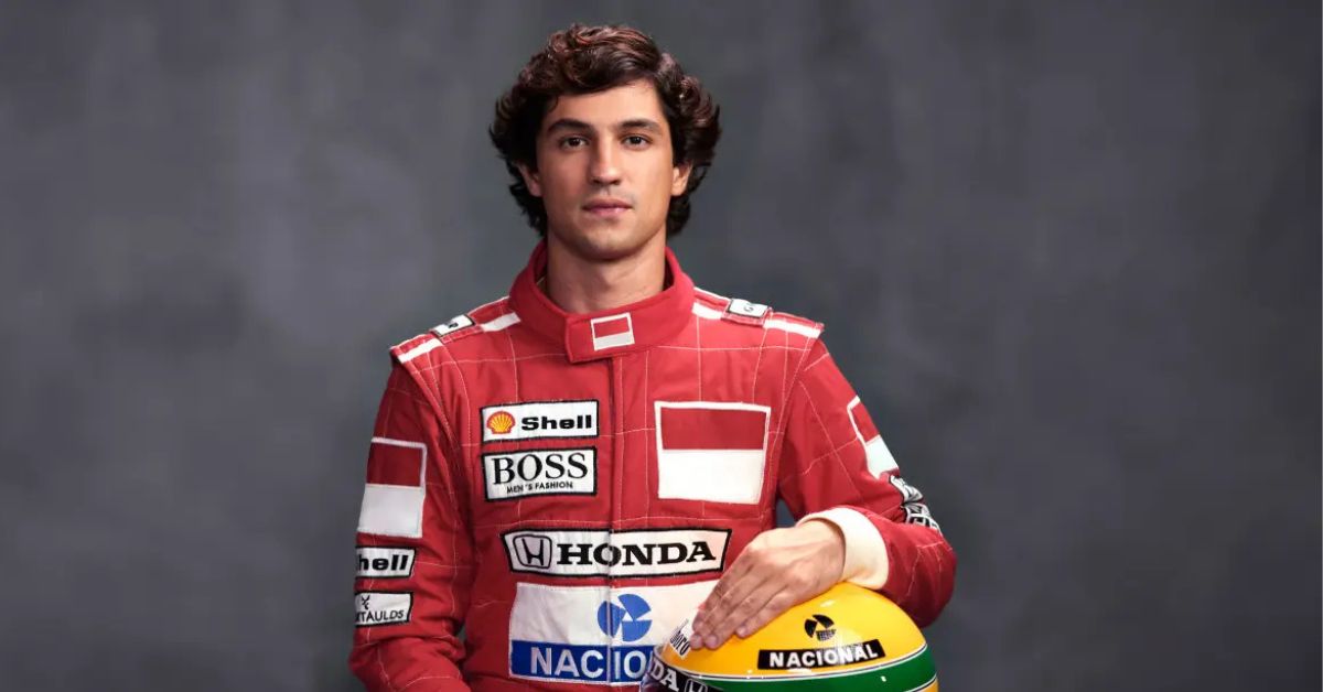 Ator caracterizado como Ayrton Senna na minissérie, vestindo macacão vermelho de corrida e segurando capacete com cores do Brasil