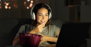 Pessoa relaxando em casa enquanto assiste a filmes leves e inspiradores.