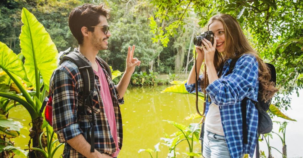 Casal sorridente durante contato com a natureza em trilha ao ar livre