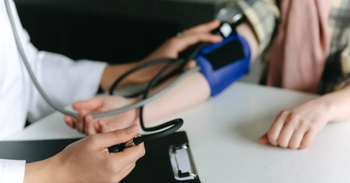Pessoa passando por medição de pressão alta com esfigmomanômetro no braço