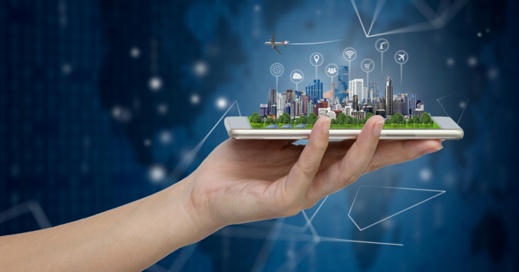 Mão segurando celular com imagem digital de cidade inteligente, representando a tecnologia e inovação urbana