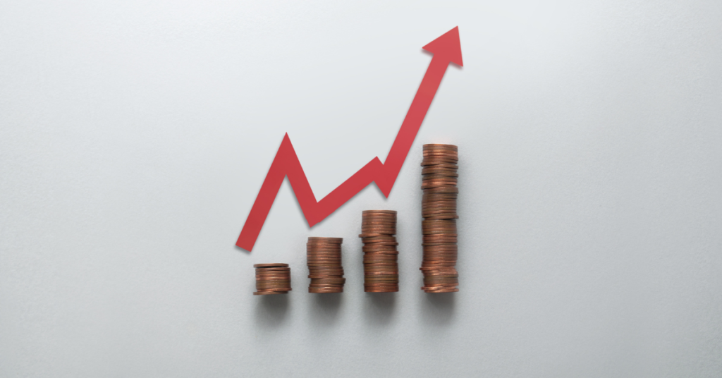 Gráfico com seta apontando para cima sobre moedas, simbolizando que o Copom eleva taxa básica.