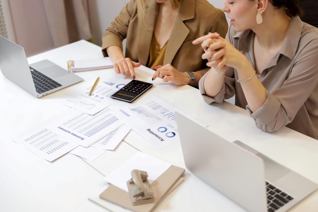 Microempreendedores discutindo sobre rendimentos e impostos, em um ambiente de trabalho.