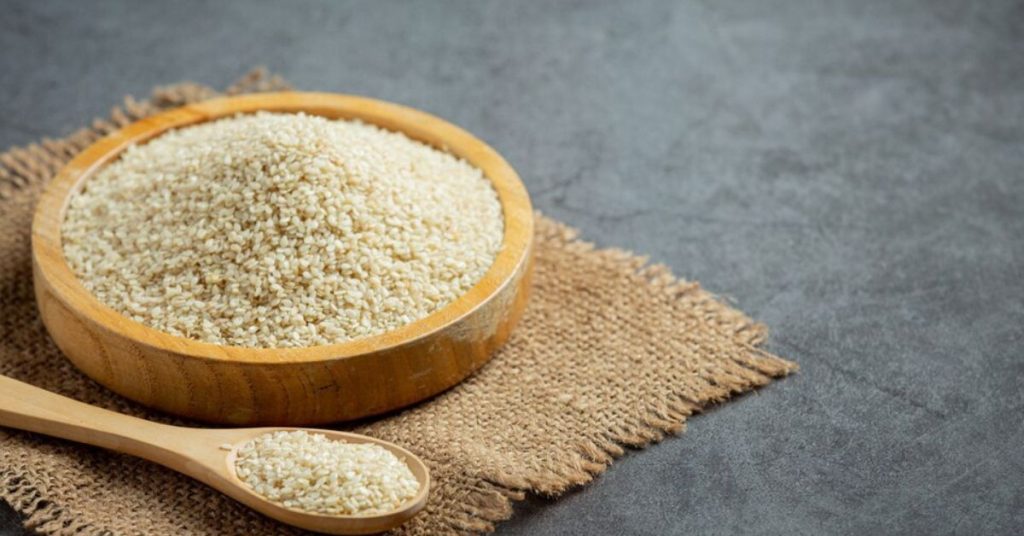 Fibras do psyllium em tigela de madeira com colher sobre tecido rústico
