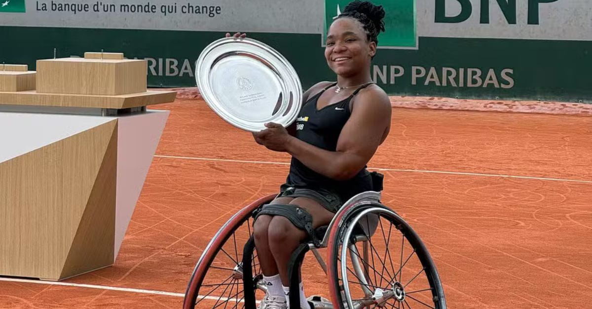 Vitória Miranda comemora título em Roland Garros juvenil em cadeira de rodas com troféu nas mãos sobre a quadra de saibro