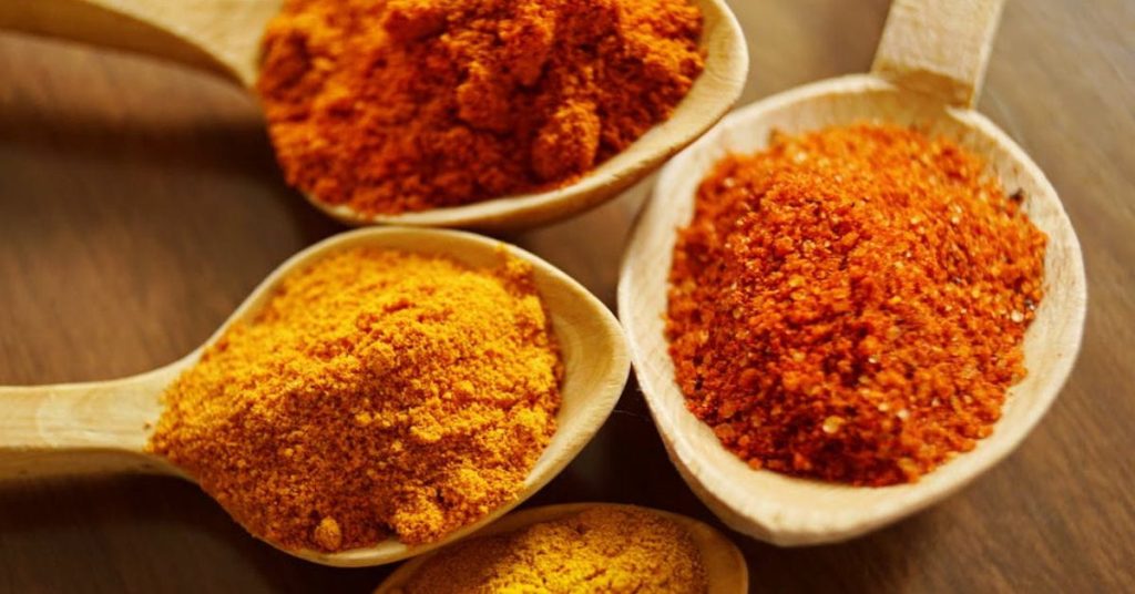 Cúrcuma em pó sendo usada para temperar alimentos saudáveis