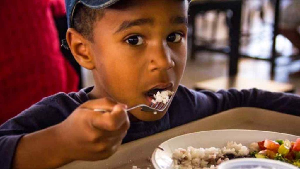 Criança se alimentando conforme o Guia alimentar brasileiro com alimentos naturais