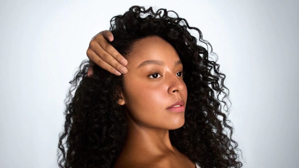 Mulher com pele radiante representando o conceito de Movimento Clean Beauty em ambiente minimalista.