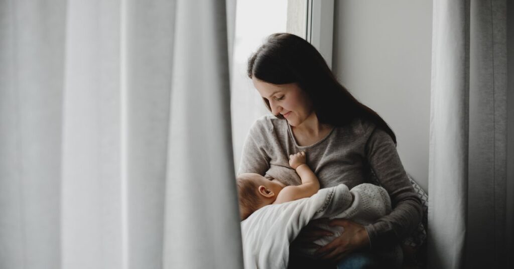 mãe amamentando bebê em ambiente calmo, simbolizando o poder imunológico do leite materno. - celulas-imunes-da-amamentacao.