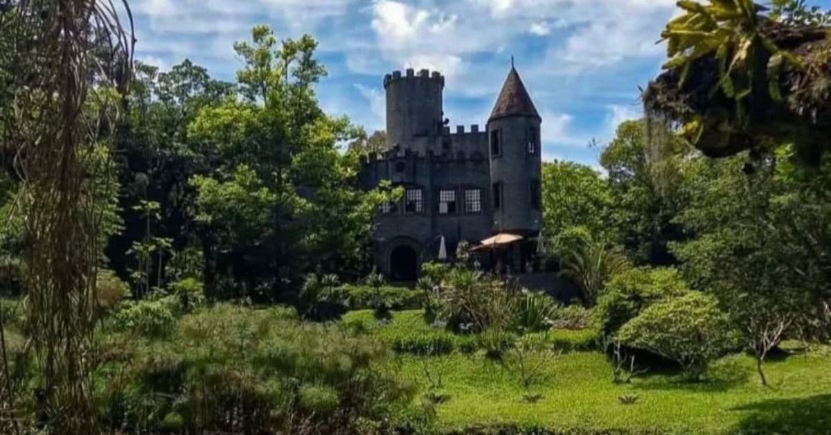 Castelo britânico em Santa Catarina cercado por natureza e torres medievais.