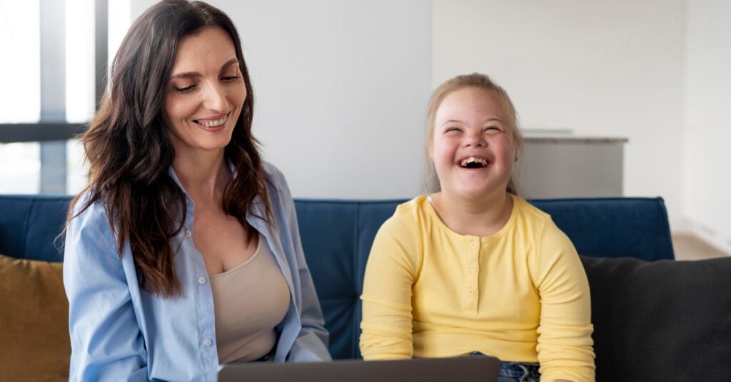 Mãe e filha com Síndrome de Down sorriem enquanto participam de atividade educativa no Instituto MoT21