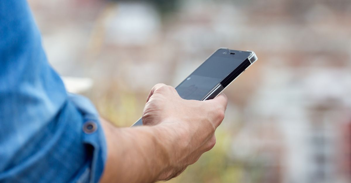Pessoa segurando smartphone durante ação da Operação Rastreio celulares RJ