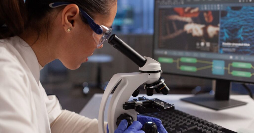 pesquisadora observa amostra em laboratório moderno durante projeto ligado à parceria Einstein–Stanford