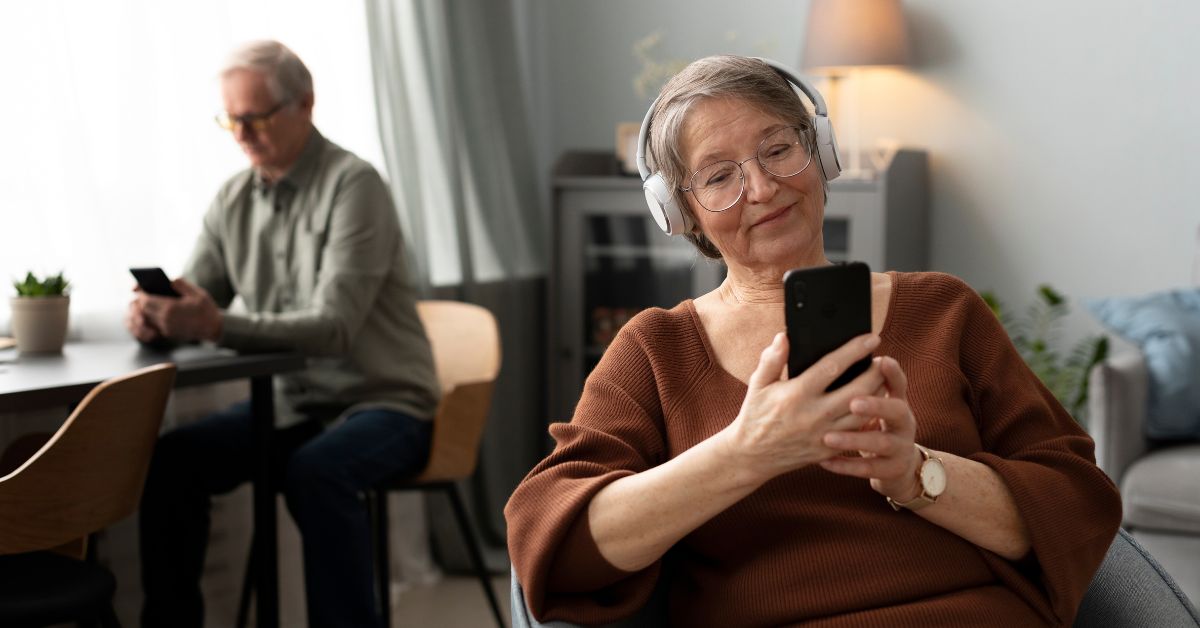 Adultos usam telemóvel em casa, ilustrando o crescimento do Uso Internet em Portugal