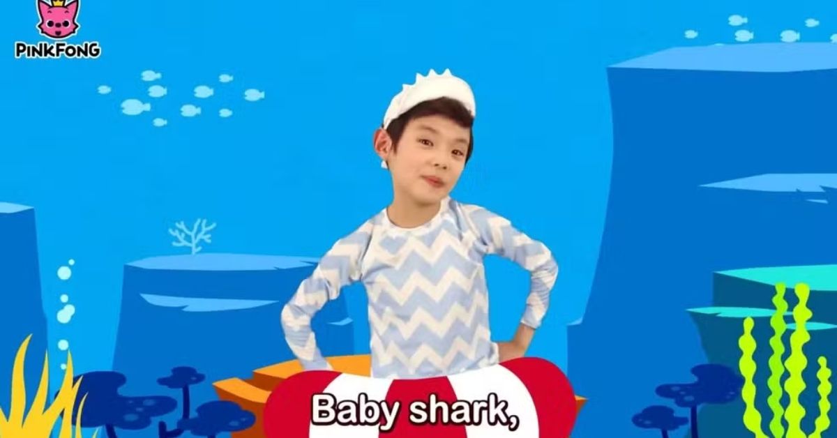 Criança dançando no clipe de Baby Shark da Pinkfong em cenário submarino colorido.