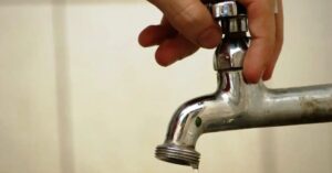 Economia de água em condomínios representada por torneira sendo fechada