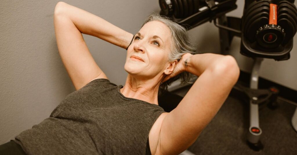 Mulher na meia-idade se exercitando para melhorar o bem-estar durante ondas de calor na menopausa.