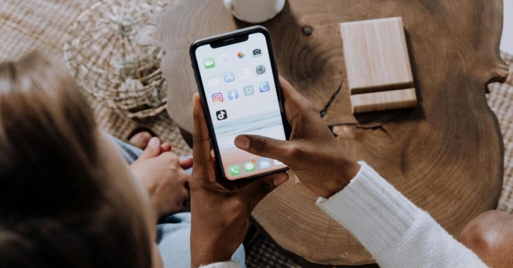 Pessoa usando o celular para acessar redes sociais, cenário que dialoga com Cambridge palavra do ano 2025.