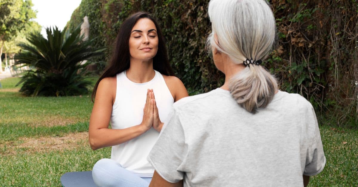 Mulher praticando meditação ao ar livre com orientação de profissional de bem-estar.