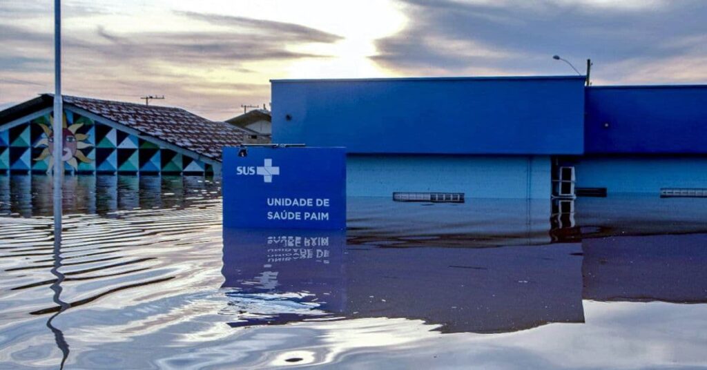 unidade do SUS alagada durante enchente mostrando impacto e necessidade de investimento para adaptação climática no SUS