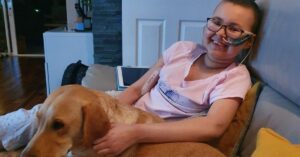 Paciente sorri ao lado de seu cão durante recuperação, simbolizando esperança em novos tratamentos e reforçando a busca por respostas sobre se leucemia tem cura.