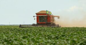 Colheitadeira em lavoura durante safra, ilustrando impacto para agricultores afetados pelo tarifaço nos EUA.