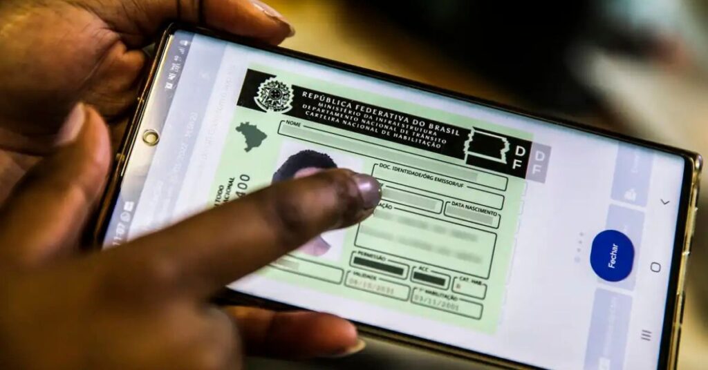 Pessoa acessa CNH sem autoescola em versão digital pelo celular.
