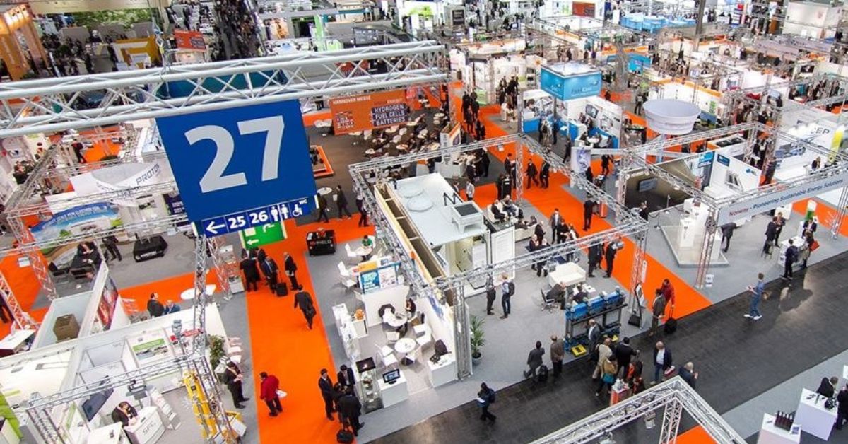 Vista aérea de estandes e visitantes em uma grande feira industrial, ilustrando o ambiente dinâmico da Feira FIEC.