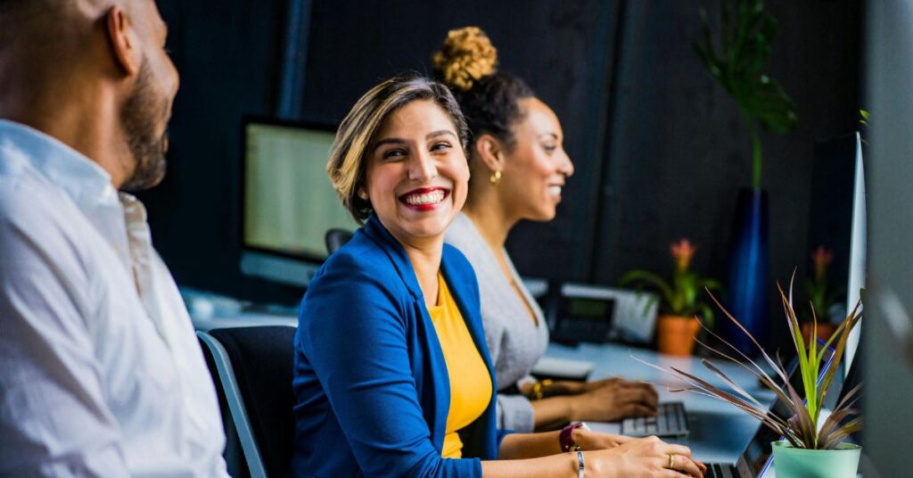 Funcionários conversam e trabalham juntos em ambiente corporativo ligado à licença para amizades