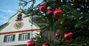 Tradições de Natal pelo mundo representadas por árvore decorada em vila europeia