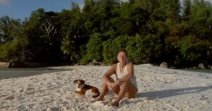 Homem sentado em praia de ilha restaurada após plantar 16 mil árvores em ilha deserta